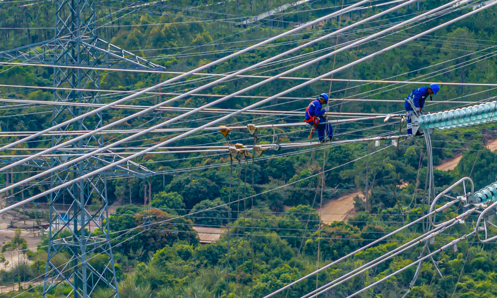 500千伏汕尾甲湖灣電廠機組擴建接入系統工程組塔架線施工現場。