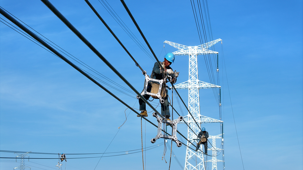 在500千伏廣東云浮云城輸變電工程現場，南方電網旗下廣東電網能源發展公司作業人員在新架線路上安裝間隔棒部件。