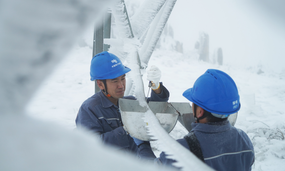 在牛從甲牛側接地極線路210號塔，南方電網超高壓公司曲靖局運維人員開展模擬導線覆冰厚度測量。