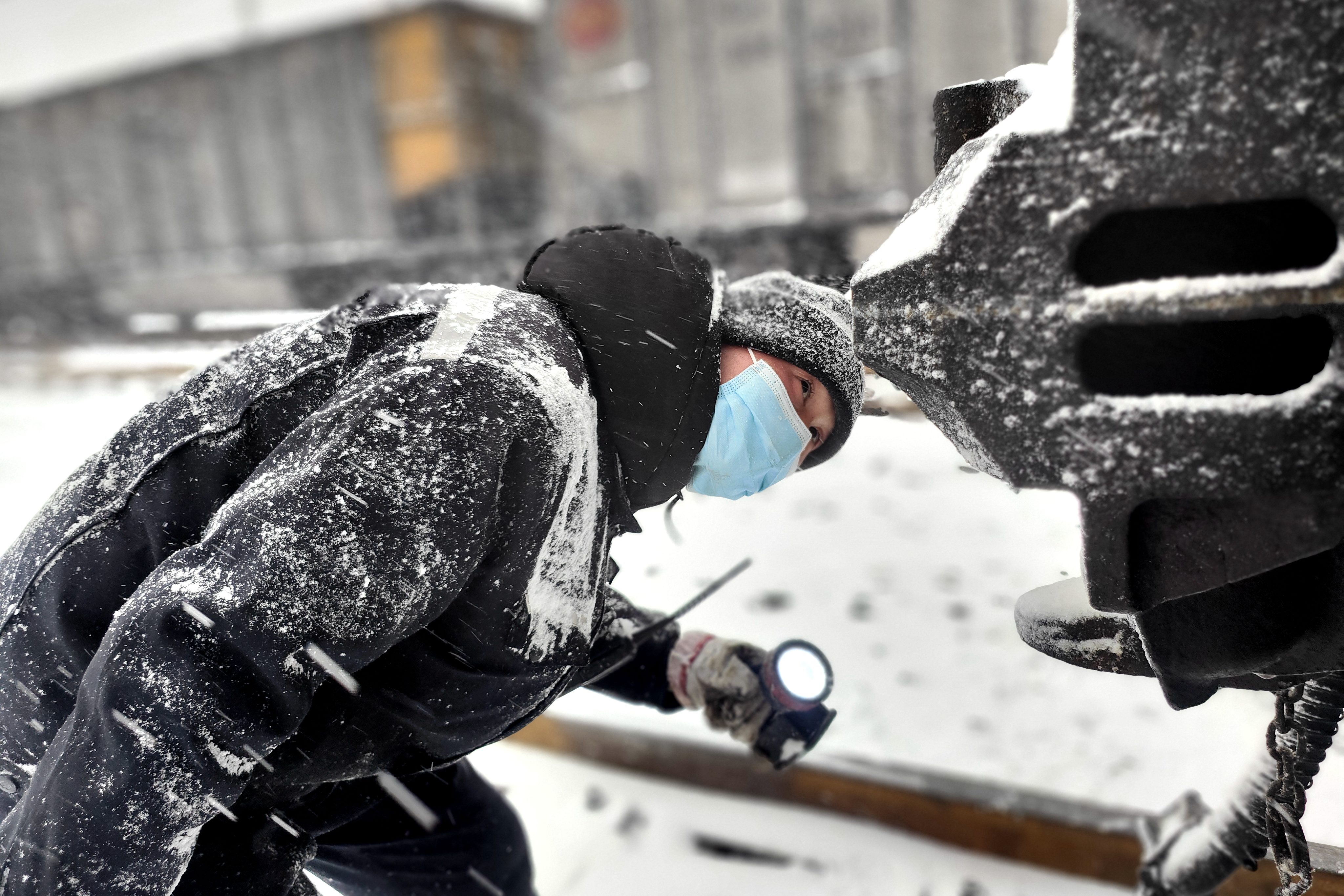 圖為1月20日鐵路裝備肅寧分公司肅寧北列檢作業場檢車員冒雪對車鉤部位進行檢查-王建_副本.jpg