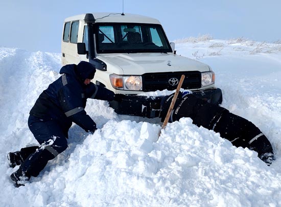 施工車輛在積雪路段被困，司機和查線工挖雪救車。.jpg