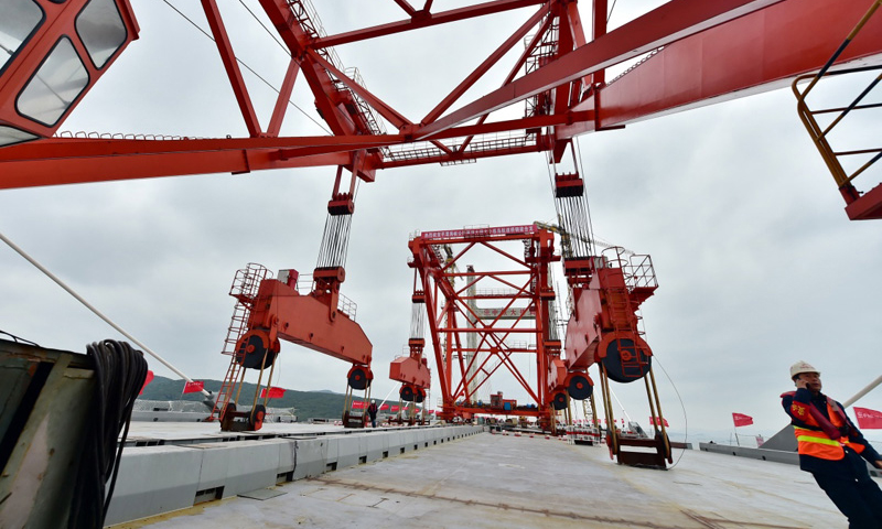 平潭海峽公鐵兩用大橋是新建福州至平潭鐵路、長(zhǎng)樂(lè)至平潭高速公路的關(guān)鍵性控制工程。圖為12月28日，平潭海峽公鐵兩用大橋大小練島水道橋上的兩臺(tái)架梁吊機(jī)在作業(yè)中。（新華社記者 林善傳 攝）
