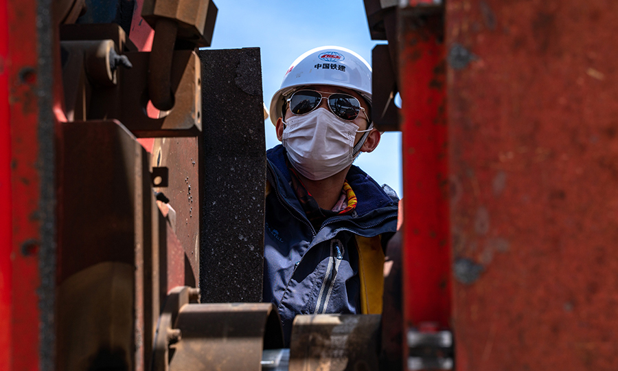 拉林鐵路無縫線路焊接的準備工作自2019年5月就已經開始。為了保證高原焊軌質量，該項目部嚴格按照國家標準，編制了《焊軌、放散首件工程施工工藝試驗》手冊，先后組織開展了工程線施工安全教育，焊軌、放散施工三級安全教育培訓，質量安全紅線管理規定宣貫學習以及焊軌、鎖定質量培訓。圖為技術人員正在調整焊軌機位置。（丁慶濱 攝）