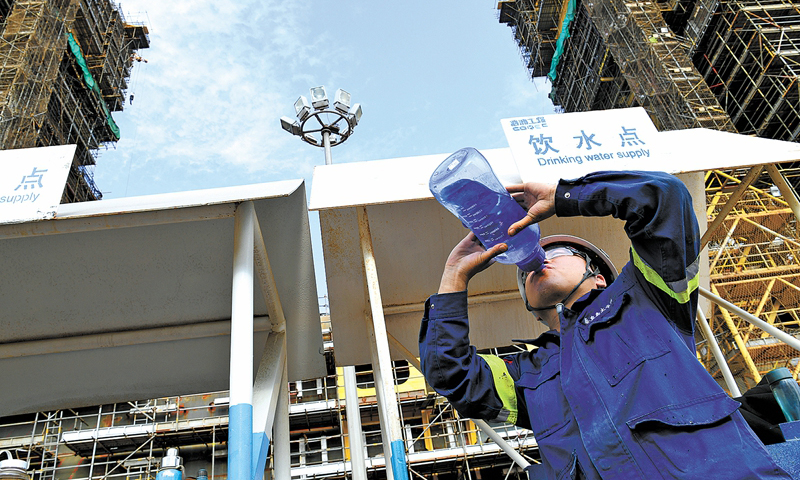 陵水17-2半潛平臺(tái)船體重約35000噸，由“回”字形浮箱和四個(gè)立柱組成，共計(jì)82個(gè)分段。這些分段在青島和煙臺(tái)建造完成后，最終集中到青島場(chǎng)地進(jìn)行總裝搭載。圖為在悶熱的船艙里作業(yè)后，施工人員大量補(bǔ)充水分。