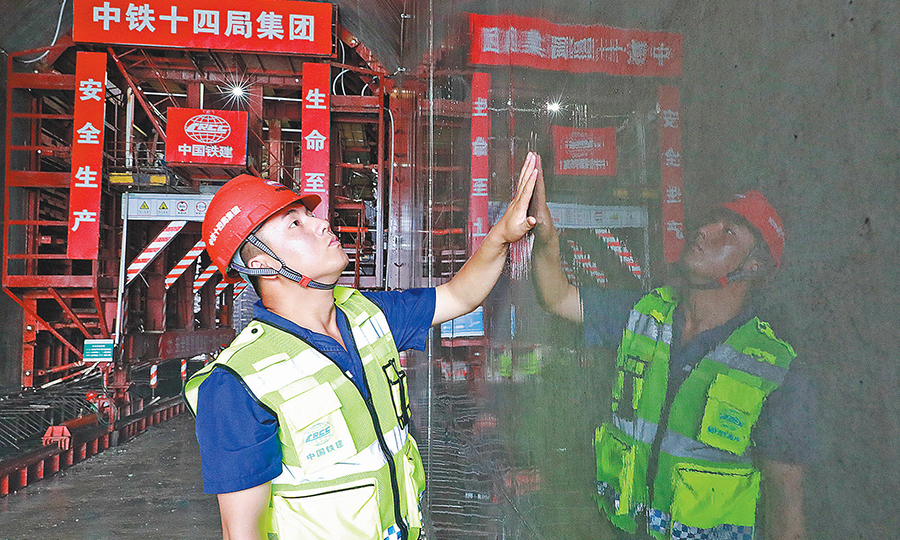 日前，中國(guó)鐵建所屬中鐵十四局二公司洛寧抽水蓄能電站項(xiàng)目部澆筑的第一倉(cāng)清水鏡面混凝土揭開(kāi)了神秘的“面紗”。圖為技術(shù)人員在查看混凝土養(yǎng)護(hù)效果。（王亮亮 攝）