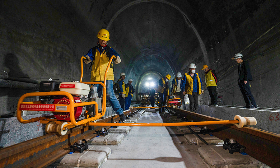 拉林鐵路是西藏首條電氣化鐵路，建成通車后將結(jié)束藏東南地區(qū)沒有鐵路的歷史，改善西藏鐵路網(wǎng)的布局和規(guī)劃，為西藏東部地區(qū)的經(jīng)濟(jì)發(fā)展注入新的活力。目前，項(xiàng)目已完成正線鋪軌126.3公里，其中有砟109.5公里、無砟15.7公里，預(yù)計(jì)今年年底完成全線鋪軌任務(wù)。圖為施工人員正在對(duì)已鋪設(shè)好的軌道安裝扣件。