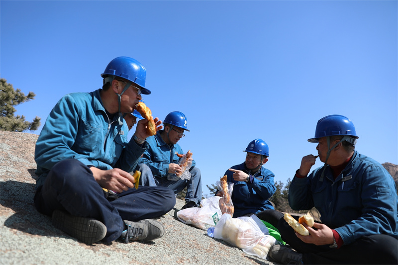 3月16日，山東榮成市供電公司員工對槎山上的電力線路進行特巡。線路巡檢了一半時正值中午，巡檢人員在山上用餐。.jpg
